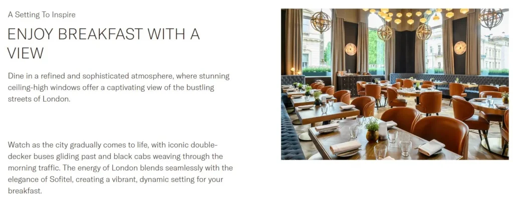 Hotel breakfast room with large windows, elegant seating and a city view